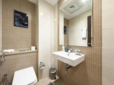 a bathroom with a sink and a toilet and a mirror at SettlerHomes- Breathtaking 2BR Marina High-Floor in Dubai