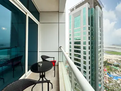 a balcony with a table and chair on a building at SettlerHomes- Breathtaking 2BR Marina High-Floor in Dubai