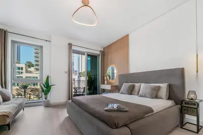 a bedroom with a large bed and a large window at Luxueux Studio, Top emplacement in Dubai