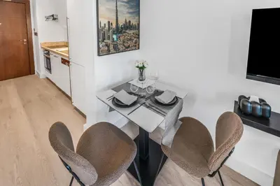 a dining room with a white table and chairs at Luxueux Studio, Top emplacement in Dubai