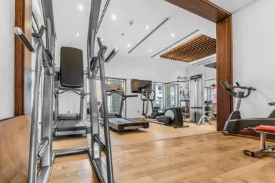 a gym with treadmills and exercise equipment in a room at Luxueux Studio, Top emplacement in Dubai