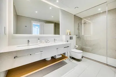 a white bathroom with a sink and a shower at Stylish sea view from new 2BD La Vie in Dubai
