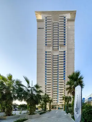 a tall building with palm trees in front of it at Stylish sea view from new 2BD La Vie in Dubai
