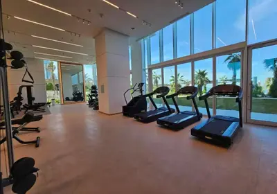 a gym with treadmills and ellipticals in a building at Stylish sea view from new 2BD La Vie in Dubai