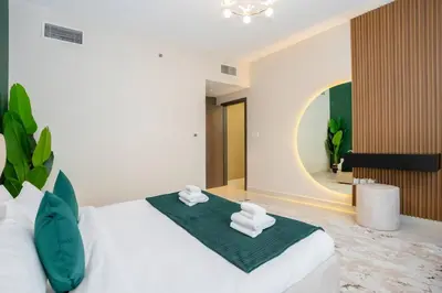 a bedroom with a large bed with towels on it at Specious pool view One Bed room in Dubai