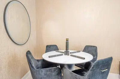 a round table with black chairs and a mirror at Specious pool view One Bed room in Dubai