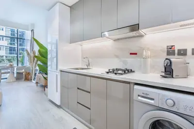 a white kitchen with a sink and a dishwasher at Artist Heaven Studio! Riviera 35! 10 min Downtown in Dubai