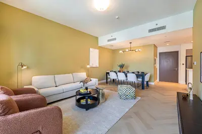 a living room with a couch and a dining room at Daniels Luxe 3BR Downtown with Skyline View in Dubai