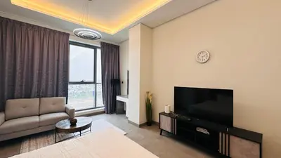 a living room with a couch and a television at Upscale Studio Apartment Palm View with Big Balcony Free Parking by Belvilla in Dubai