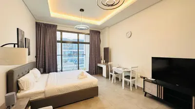 a bedroom with a bed and a desk and a television at Upscale Studio Apartment Palm View with Big Balcony Free Parking by Belvilla in Dubai