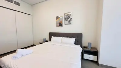 a bedroom with a large bed with white sheets at Upscale Studio Apartment Palm View with Big Balcony Free Parking by Belvilla in Dubai