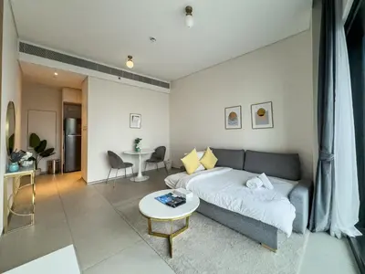 a living room with a couch and a table at SettlerHomes - Chic Jumeirah Gate with Beach Access in Dubai