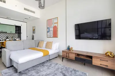 a living room with a couch and a flat screen tv at Frank Porter - Socio Tower 2 in Dubai