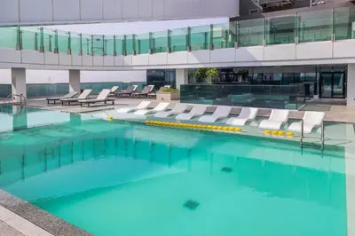 a swimming pool with lounge chairs in a building at Frank Porter - 1 Residences in Dubai