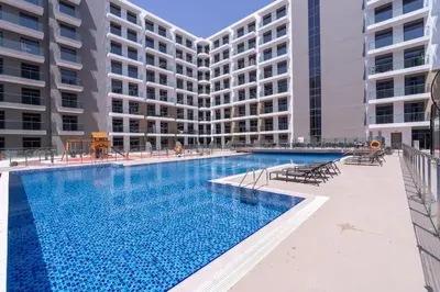 a large swimming pool in front of a building at Brand New Building * Czechin * Studio City in Dubai