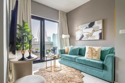 a living room with a blue couch and a large window at Frank Porter - Zada Tower in Dubai
