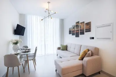 a living room with a couch and a table at Stylish 2 bedroom apartment in Sobha Hartland in Dubai