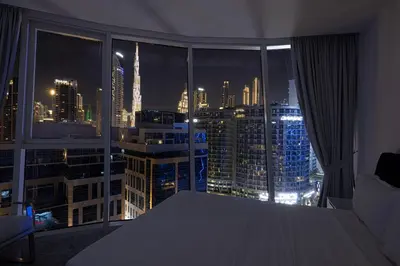 a room with a view of a city at night at Panoramic LUX Apartment with Burj Khalifa View in Dubai