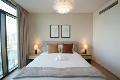 a bedroom with a large white bed with two lamps at The Palace 405 I Luxury 2BD I Dubai Creek Harbour in Dubai