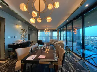 a living room with a dining table and a large chandelier at Luxurious 2BR in MBL JLT Brand New in Dubai