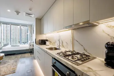 a kitchen with a stove top oven next to a sink at Livbnb - Sea and Marina View, Steps to Marina Walk in Dubai