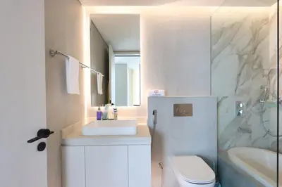 a bathroom with a sink and a toilet and a mirror at Livbnb - Sea and Marina View, Steps to Marina Walk in Dubai