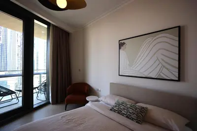 a bedroom with a bed and a chair and a window at Elegant 1BR Oasis Burj Vista Steps to Burj Khalifa - 11AB08 in Dubai