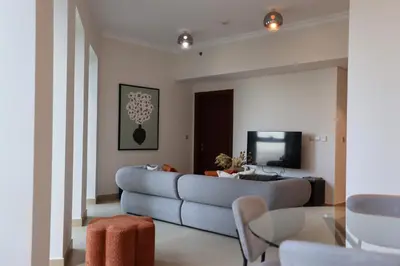 a living room with a couch and a tv at Elegant 1BR Oasis Burj Vista Steps to Burj Khalifa - 11AB08 in Dubai