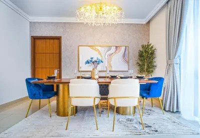 a dining room with a table and blue chairs at EasyGo - Upgraded 2BDR in BLVD Point with Burj Khalifa View in Dubai