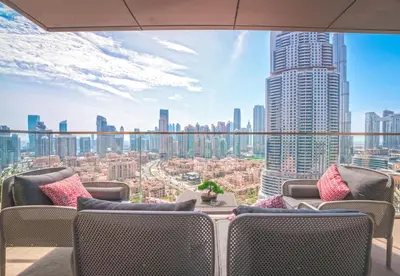 a balcony with chairs and a view of a city at EasyGo - Upgraded 2BDR in BLVD Point with Burj Khalifa View in Dubai