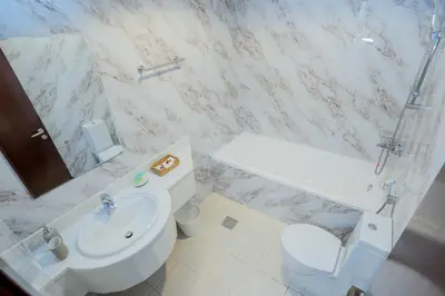a white bathroom with a toilet and a sink at VIBES by Beds and Company - 51st Floor, Full Sea View in Dubai