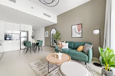 a living room with a green couch and a table at Silkhaus Ultra Luxury 1BDR in New Tower of Downtown in Dubai
