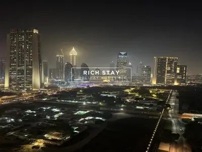 a city skyline at night with a sign that reads right stay at Incredible 1BR, Downtown Views II near Dubai Mall in Dubai