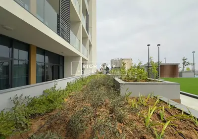 a building with a bunch of plants in front of it at Exceptional 1 BR in Prive Residences Dubai Hills in Dubai
