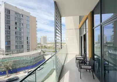 a balcony with chairs and a view of a city at Exceptional 1 BR in Prive Residences Dubai Hills in Dubai