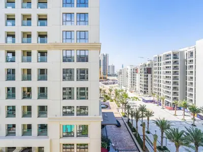 an apartment building with palm trees and buildings at Dubai Creek Escape: Luxury 3BR Nautical Grandeur in Dubai