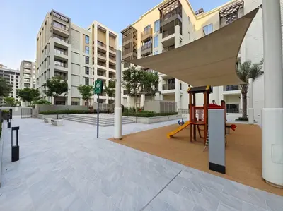 a playground in front of a building with a swing at Dubai Creek Escape: Luxury 3BR Nautical Grandeur in Dubai