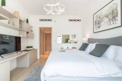 a white bedroom with a large white bed with pillows at FIRST CLASS 1BR Tranquil Oasis in Old Town in Dubai