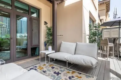a white couch sitting on a porch next to a door at FIRST CLASS 1BR Tranquil Oasis in Old Town in Dubai
