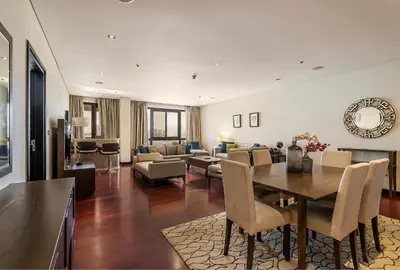 a dining room and living room with a table and chairs at Anantara South Residences I Stunning 1 Bedroom Apartment in Dubai