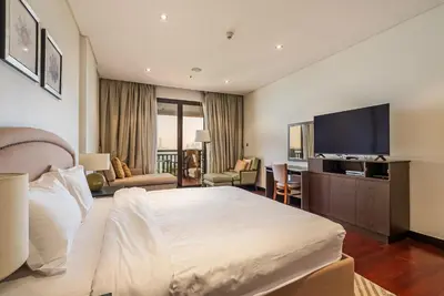 a hotel room with a bed and a flat screen tv at Anantara South Residences I Stunning 1 Bedroom Apartment in Dubai