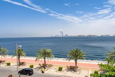 a view of a body of water with palm trees at Anantara South Residences I Stunning 1 Bedroom Apartment in Dubai