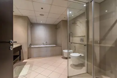 a bathroom with a shower and a toilet and a tub at Anantara South Residences I Stunning 1 Bedroom Apartment in Dubai