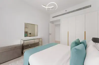 a white bedroom with a bed and a mirror at Maison Privee - Seaside JBR Living w/ Open Sea & Bluewaters Views in Dubai