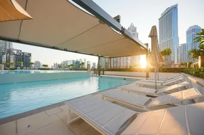 a pool with chaise lounge chairs and a swimming pool at Burj Crown - First Class Boulevard View, 9 min Walk Dubai Mall in Dubai