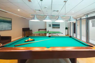 a pool table in a room with two ping pong tables at Luxury Studio, 29 Boulevard near Burj Khalifa Downtown - Chalet Homes in Dubai