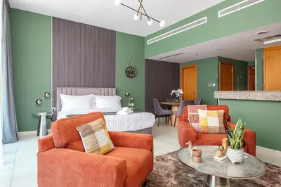 a hotel room with a bed and two chairs and a table at Escape24 Spacious Studio with Balcony near Dubai Mall in Dubai