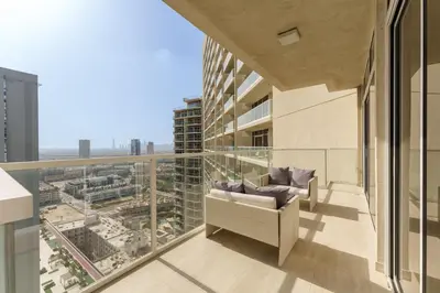 a balcony with a couch and a view of a city at Luxury Living resort style in Zaya Hameni in Dubai