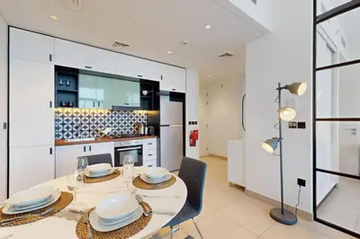 a dining room with a table and chairs in a kitchen at Socio Tower 2 - Neat Two Bedroom in Dubai