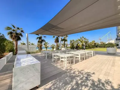 a group of tables and chairs under a large umbrella at Fantastic and Rare 4BR+maid's in JBR Walk in Dubai